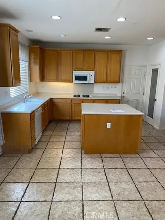 a kitchen with stainless steel appliances a stove a sink a counter top space and cabinets