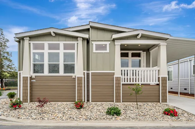 a view of a house with a small yard and wooden fence