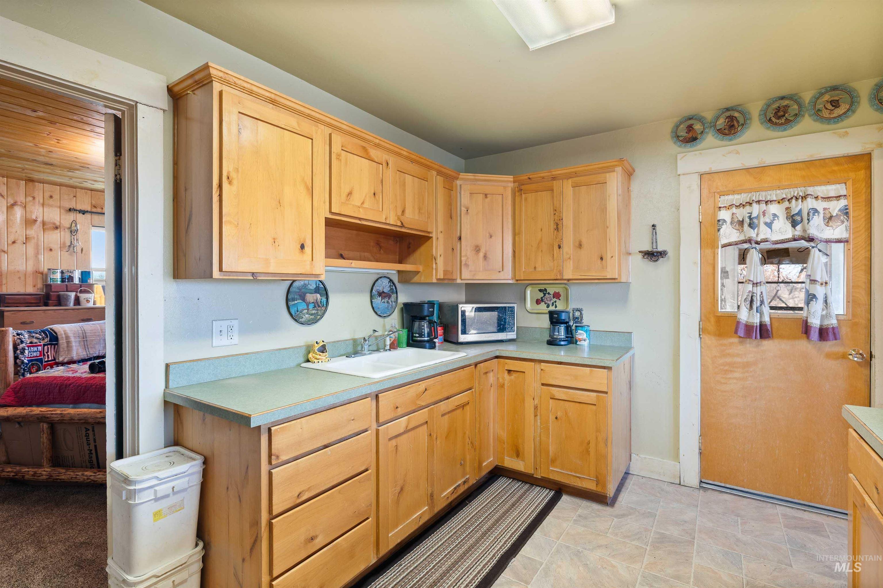 1898 East 3700th Street North Filer, ID 83328 - Photo 12 of 40 Kitchen with light wood finish cabinets, open shelves, light countertops, and stainless steel microwave