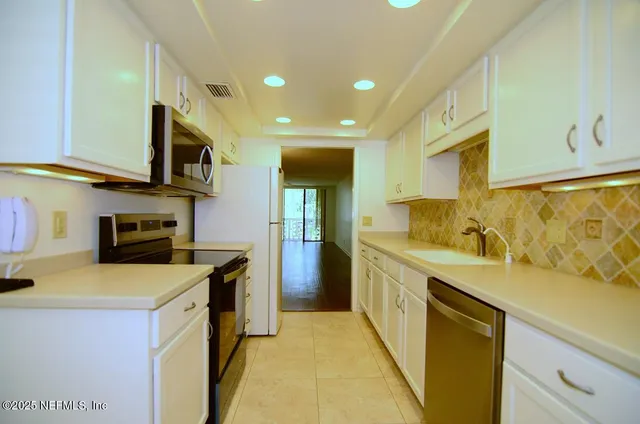 an empty room with wooden floor and chandelier