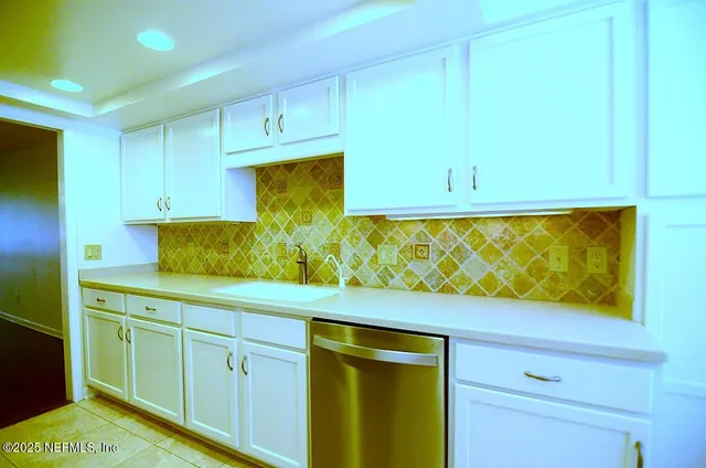 an empty room with windows and chandelier fan