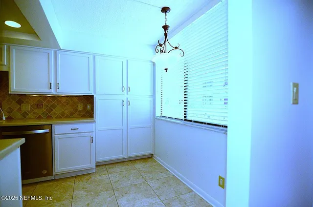 an empty room with closet and a chandelier fan