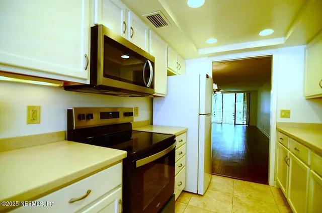 an empty room with a chandelier fan and a chandelier fan