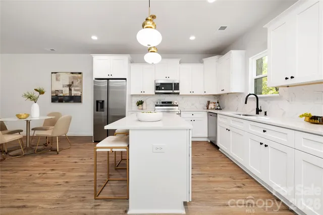 a kitchen with white cabinets and stainless steel appliances