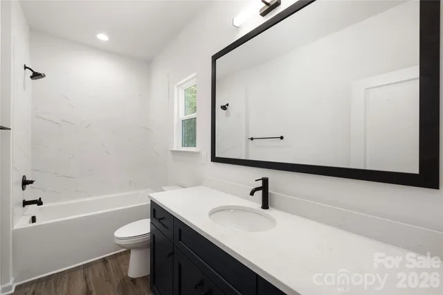 a bathroom with a sink toilet vanity and shower