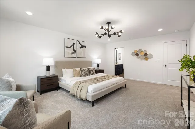 a spacious bedroom with a bed and a chandelier
