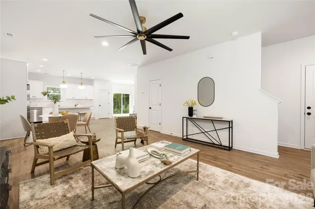 a living room with furniture a window and a ceiling fan