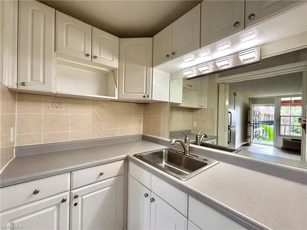 a kitchen with granite countertop a sink and cabinets