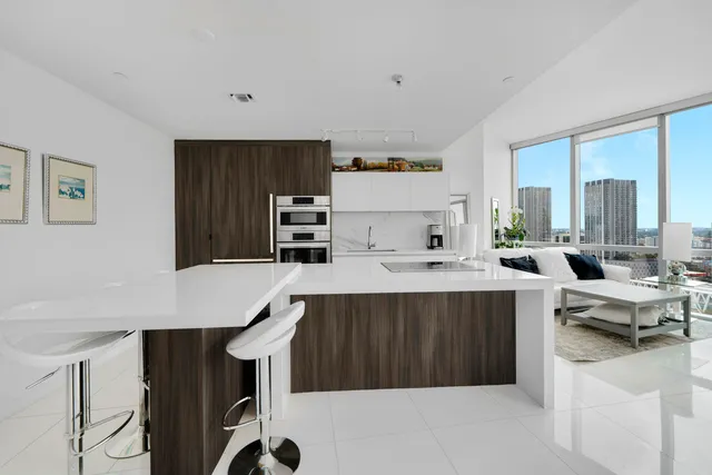 a kitchen with stainless steel appliances a table chairs and a refrigerator