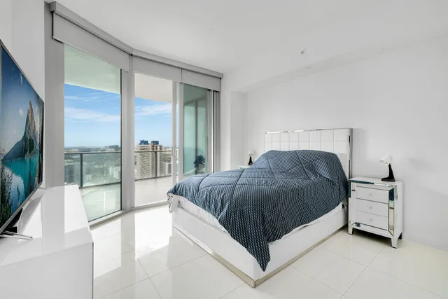 a spacious bedroom with a bed and glass door