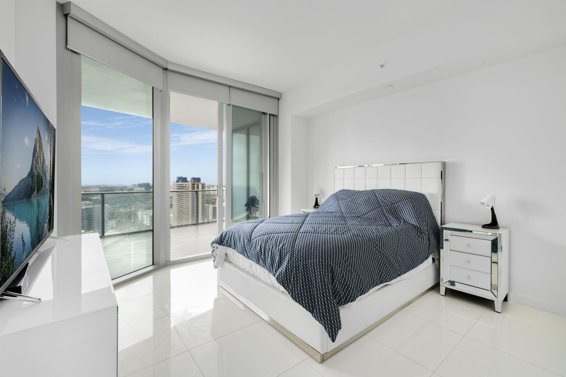 851 Northeast 1st Avenue, Unit 2410 Miami, FL 33132 - Photo 18 of 27 a spacious bedroom with a bed and glass door