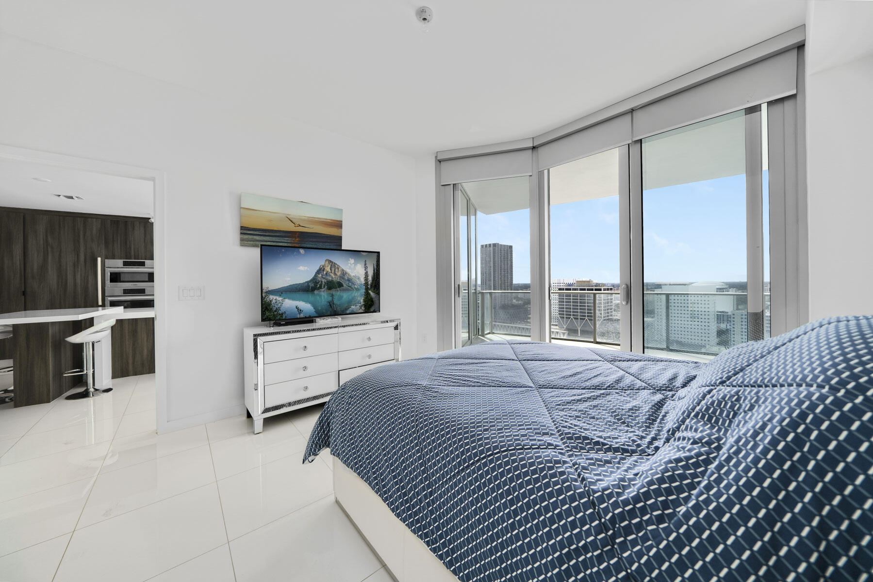 851 Northeast 1st Avenue, Unit 2410 Miami, FL 33132 - Photo 19 of 27 a bedroom with a large bed and a flat tv screen on dresser