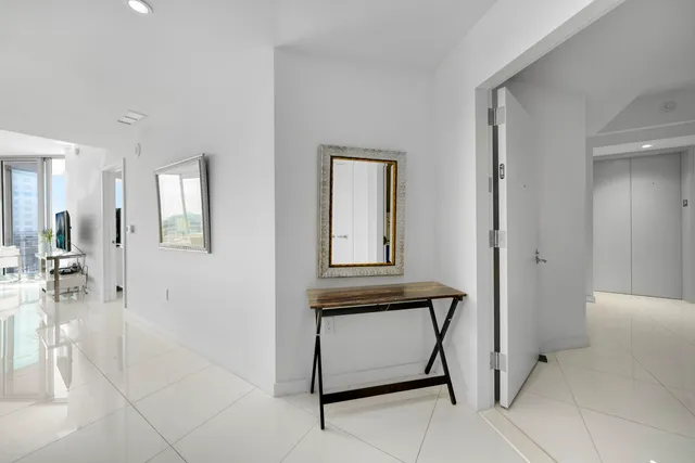 a view of a hallway with dining area and chandelier