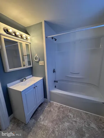 a bathroom with a tub sink and mirror