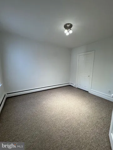 a view of an empty room and chandelier fan