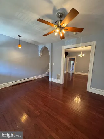 a view of a livingroom with a ceiling fan and wooden floor
