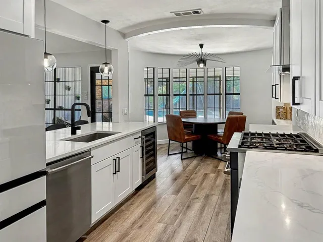 a kitchen with stainless steel appliances a stove a sink and a refrigerator