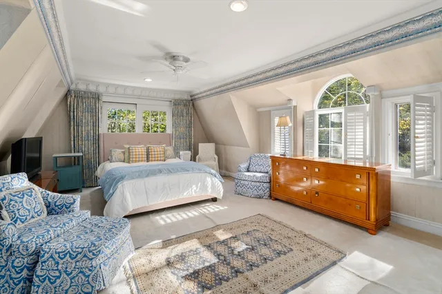 a spacious bedroom with two beds and a dresser next to a window