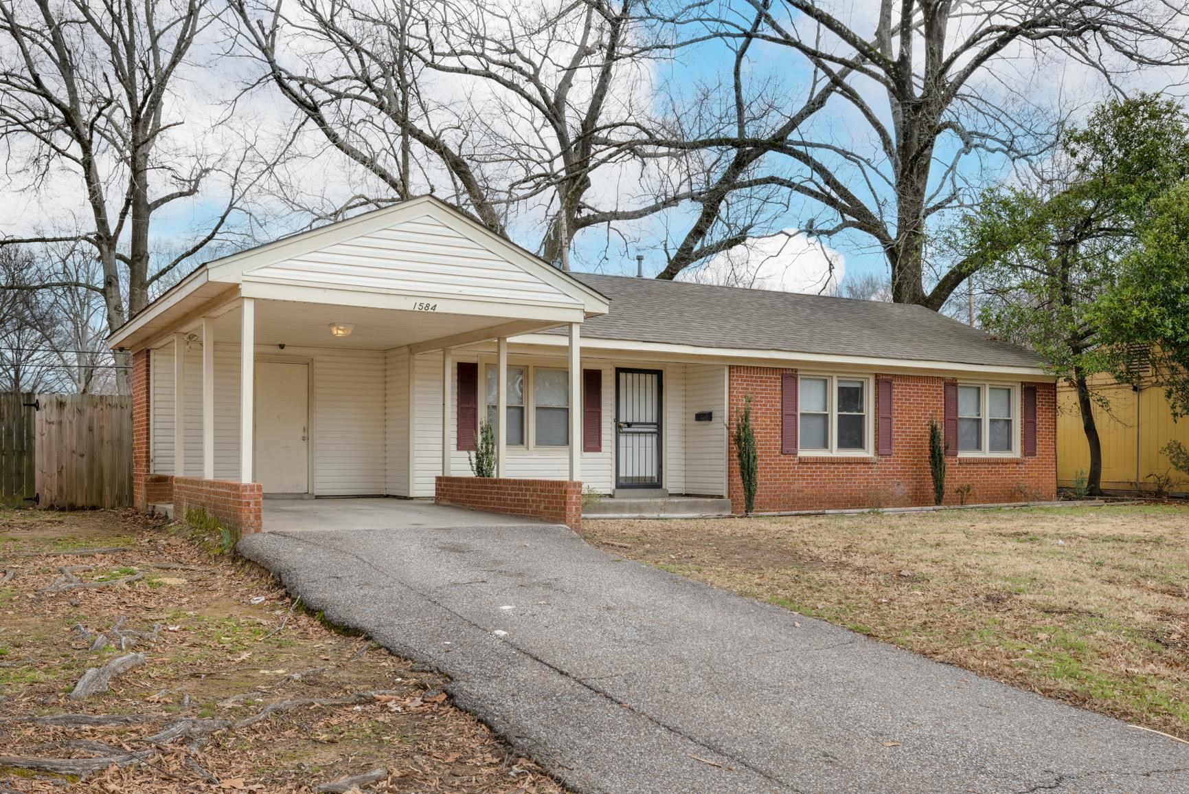 1584 South Perkins Road Memphis, TN 38117 - Photo 1 of 21 Ranch-style home featuring aphalt driveway, fence, brick siding, and a carport