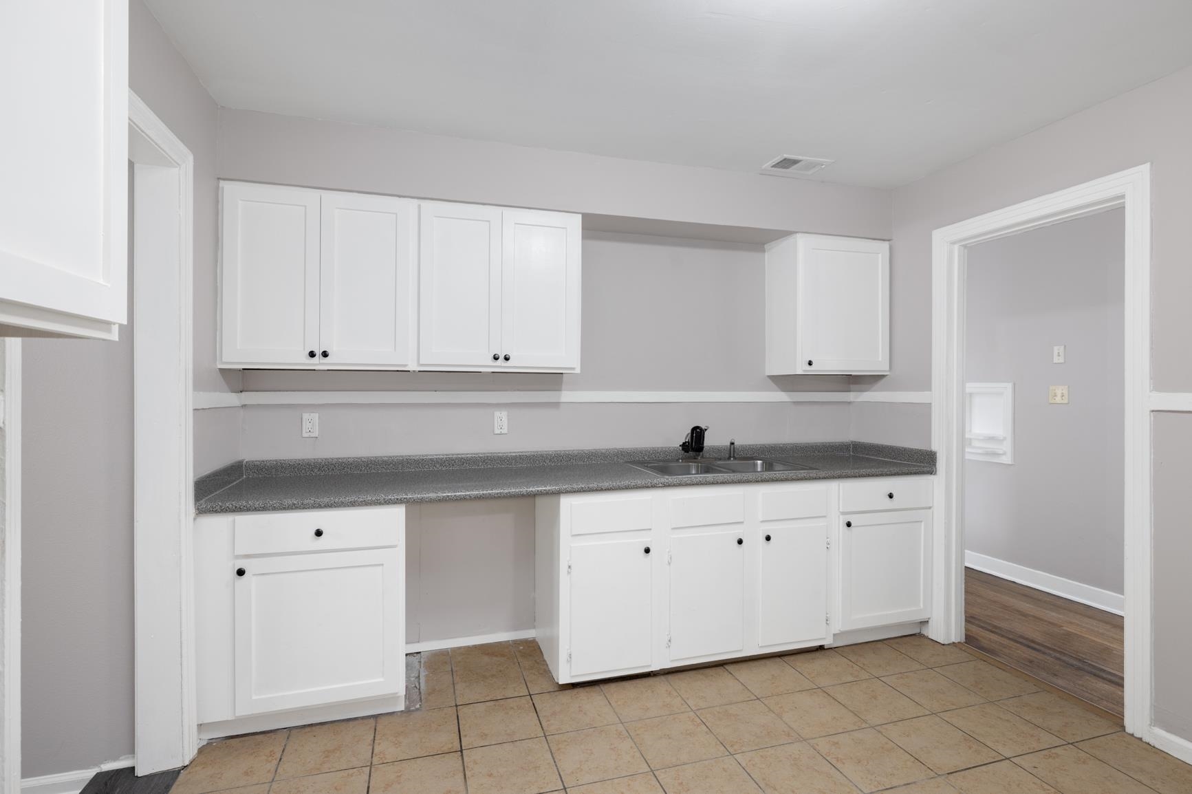 1584 South Perkins Road Memphis, TN 38117 - Photo 14 of 21 Kitchen with a sink, visible vents, dark countertops, and white cabinets