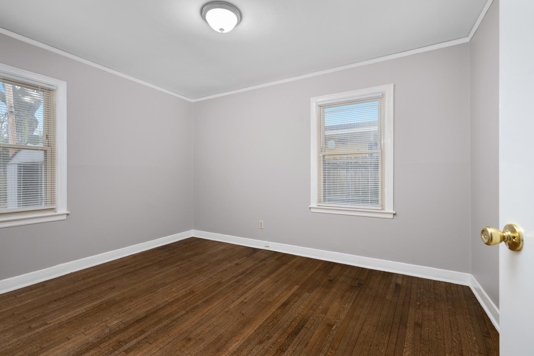 1584 South Perkins Road Memphis, TN 38117 - Photo 18 of 21 Spare room with baseboards, dark wood-type flooring, and crown molding