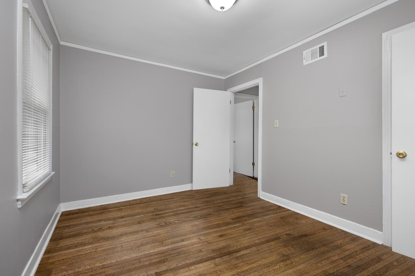 1584 South Perkins Road Memphis, TN 38117 - Photo 19 of 21 Unfurnished bedroom featuring visible vents, ornamental molding, baseboards, and wood finished floors