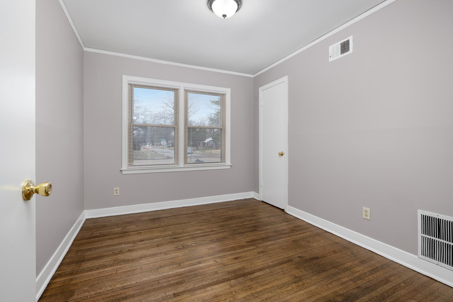1584 South Perkins Road Memphis, TN 38117 - Photo 20 of 21 Empty room featuring visible vents, dark wood-type flooring, crown molding, and baseboards