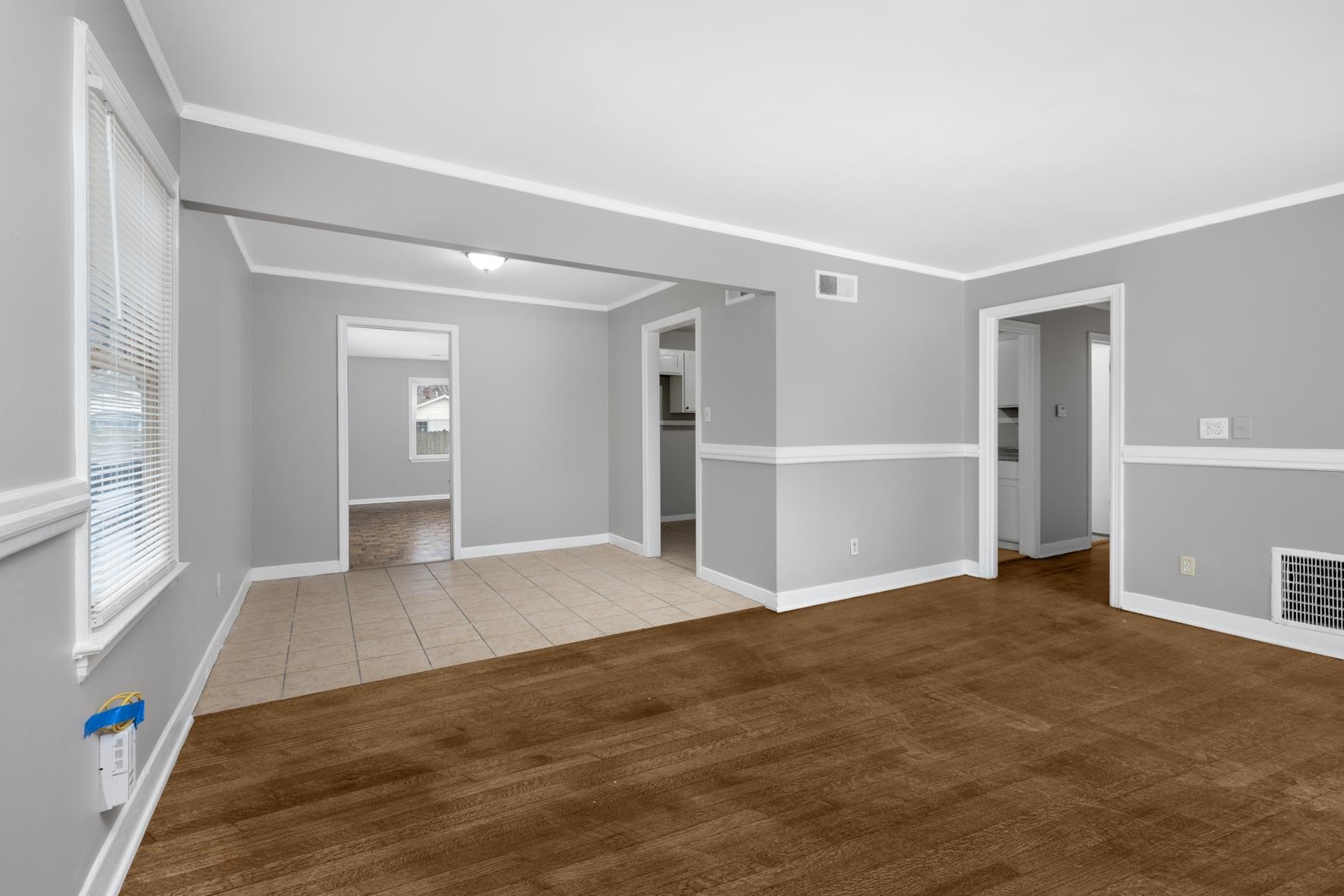 1584 South Perkins Road Memphis, TN 38117 - Photo 6 of 21 Tiled empty room featuring a healthy amount of sunlight, visible vents, and ornamental molding
