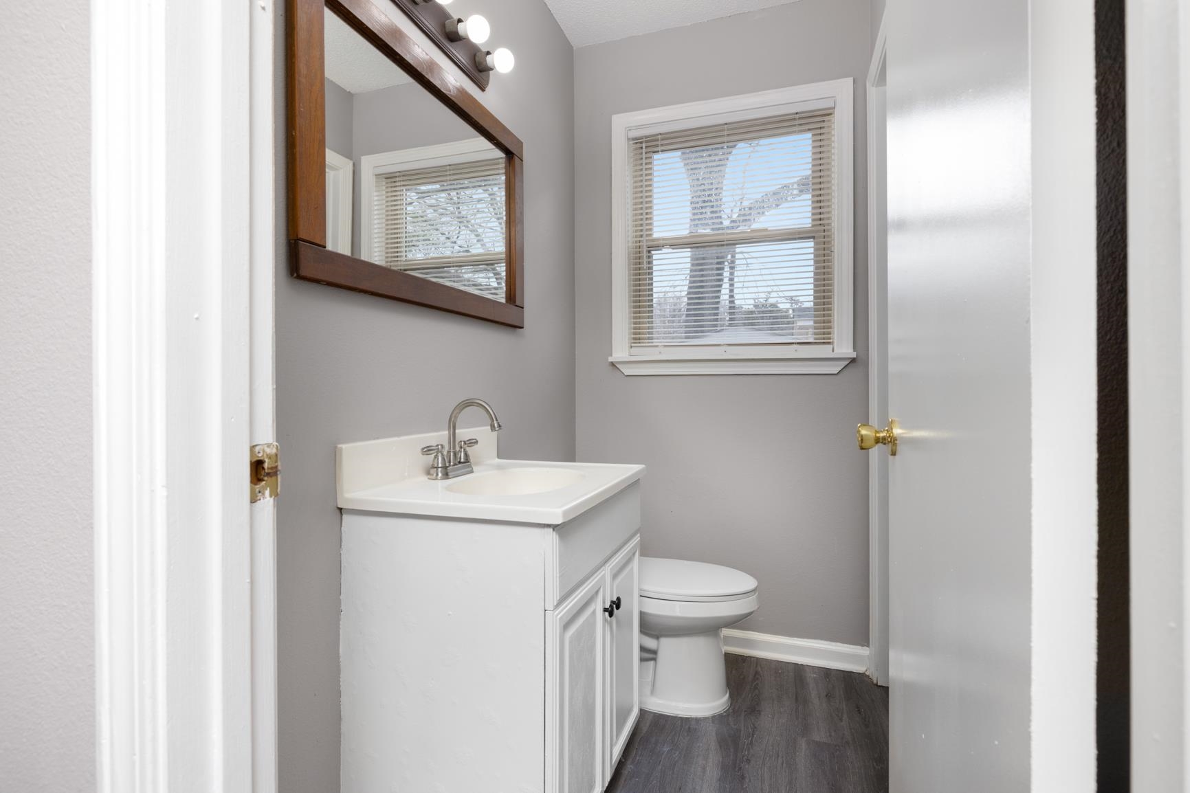 1584 South Perkins Road Memphis, TN 38117 - Photo 9 of 21 Bathroom featuring vanity, toilet, wood finished floors, and baseboards