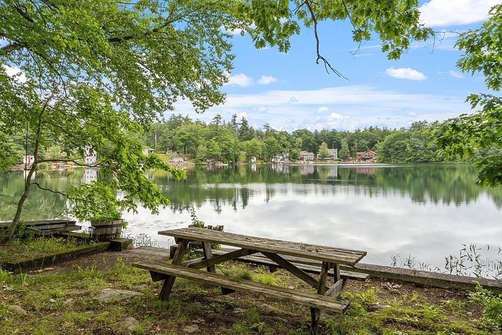 50 Sauna Row Road Townsend, MA 01474 - Photo 21 of 41 a view of a lake with a bench and trees in the background