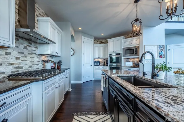 a kitchen with kitchen island granite countertop a sink stainless steel appliances and cabinets