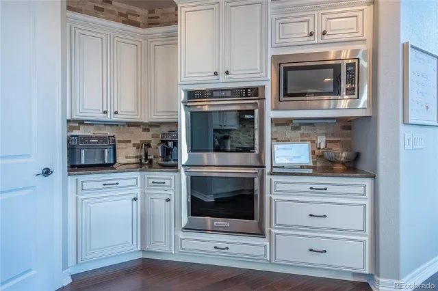 a kitchen with white cabinets and stainless steel appliances