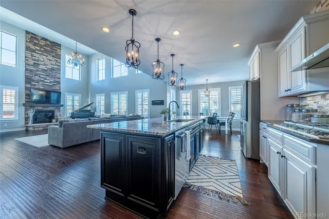 a kitchen with stainless steel appliances granite countertop wooden floors stove top oven and cabinets