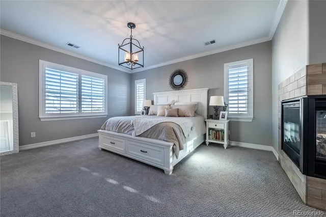 a bedroom with a bed chandelier and a window