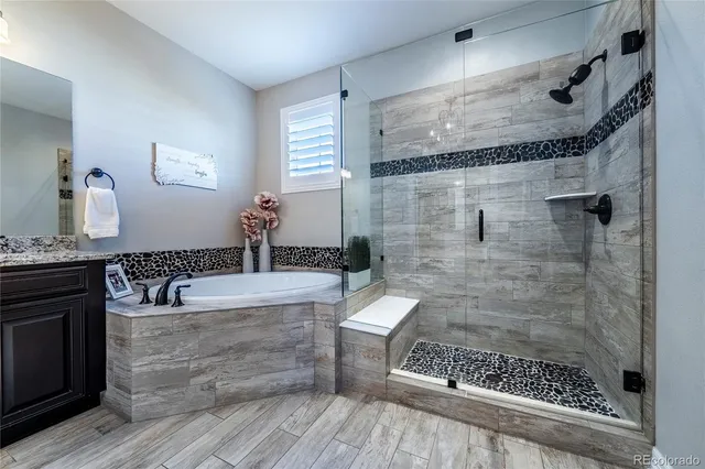 a bathroom with a bathtub a mirror and a shower