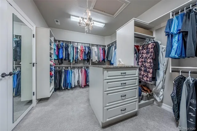 a view of walk in closet with clothes and shoes