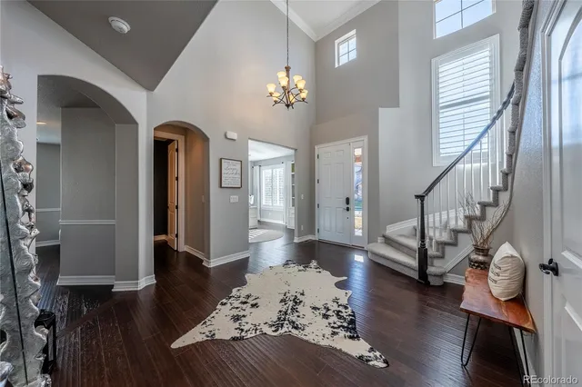 a living room with wooden floor furniture and a chandelier