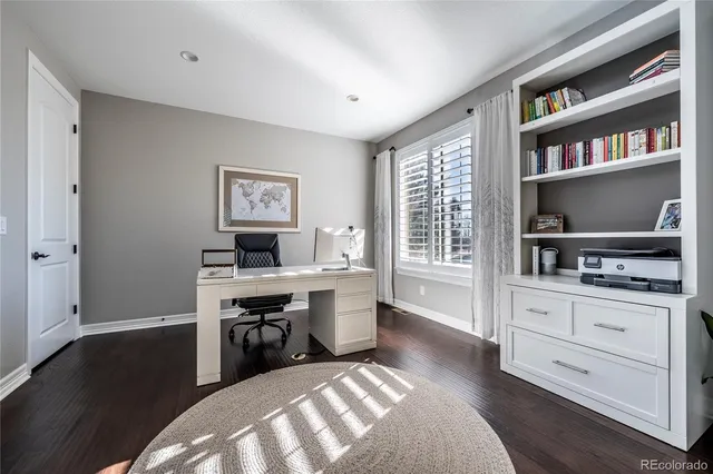 a view of a workspace with furniture and bookshelf