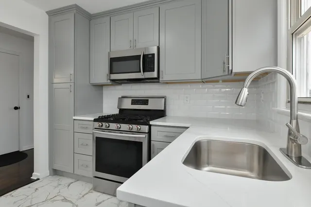 a kitchen with white cabinets and a stove top oven