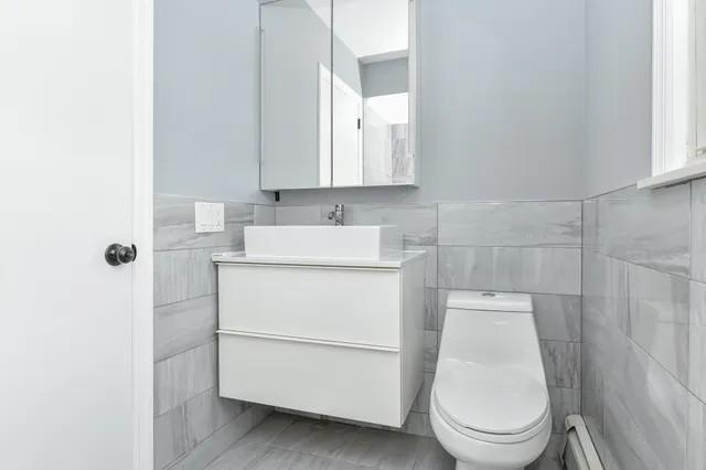 a bathroom with a toilet sink and mirror
