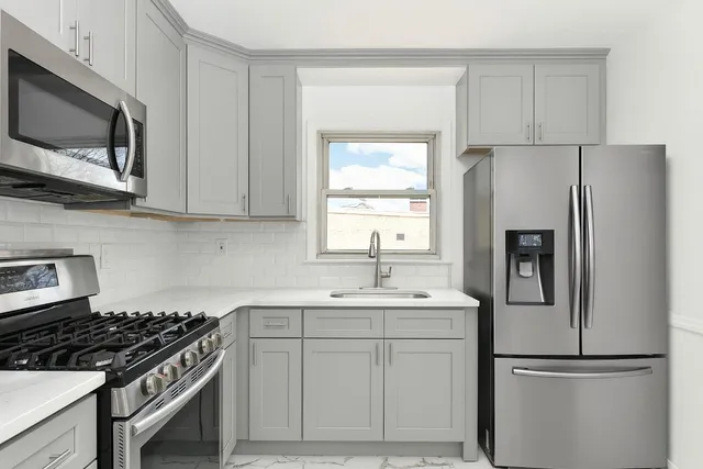 a kitchen with stainless steel appliances a refrigerator stove and microwave