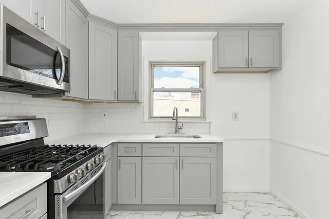 a kitchen with stainless steel appliances granite countertop a sink stove top oven and microwave