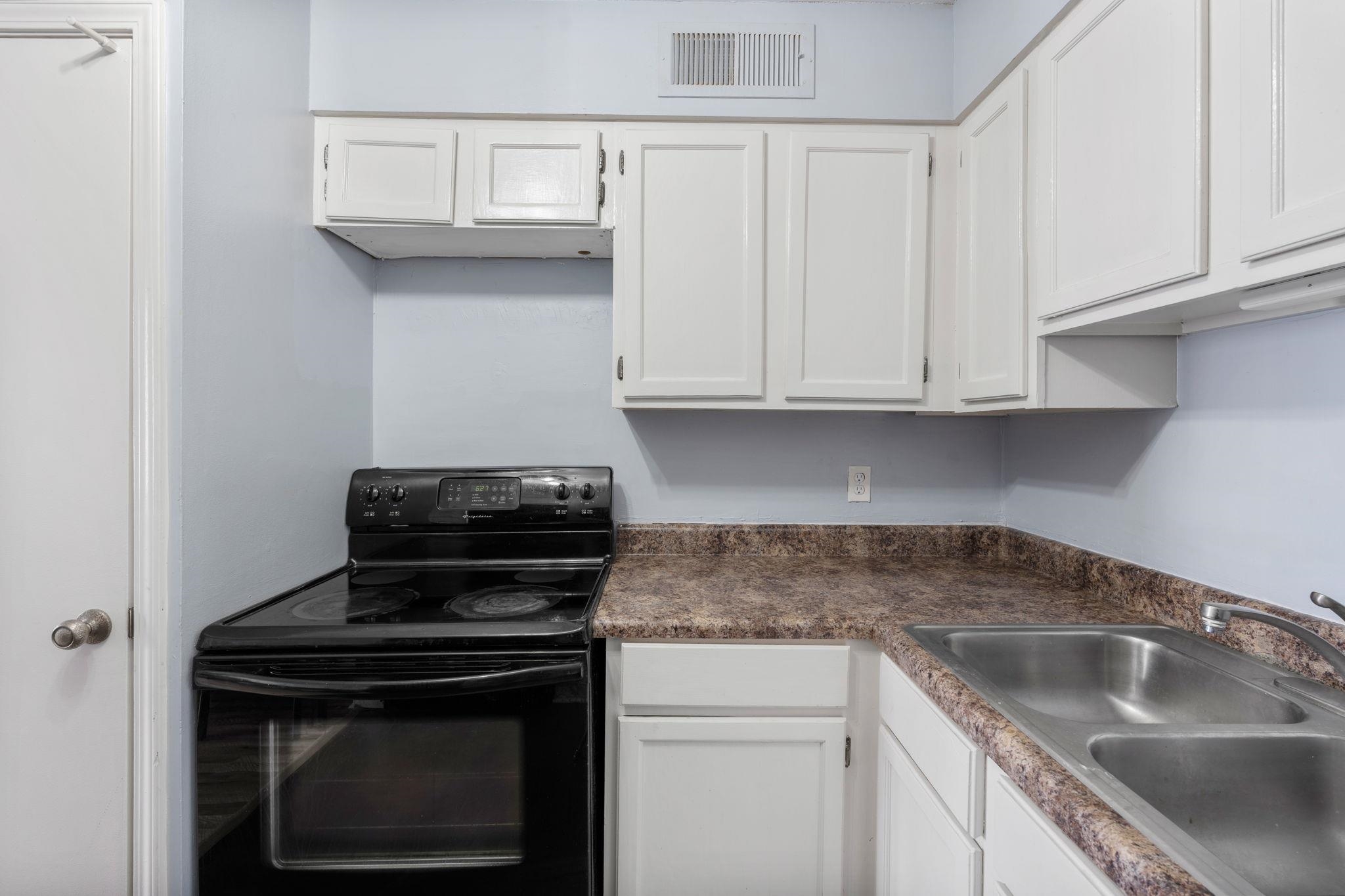 109 North Main Street, Unit 710 Memphis, TN 38103 - Photo 15 of 37 Kitchen featuring black electric range, white cabinetry, and dark countertops