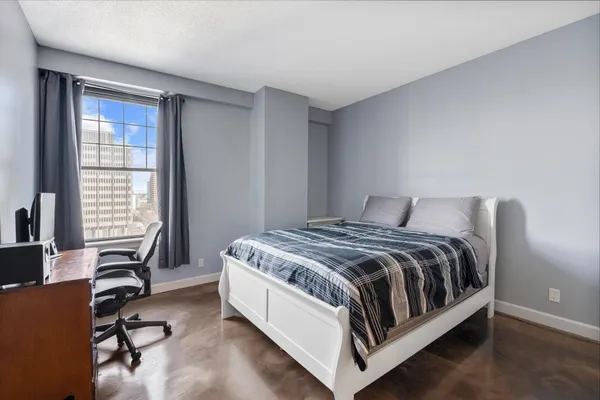 a bed sitting in a bedroom next to a window