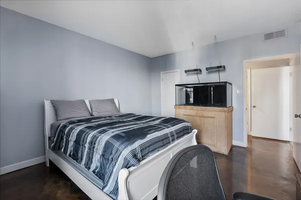 a bedroom with a bed and a view of kitchen