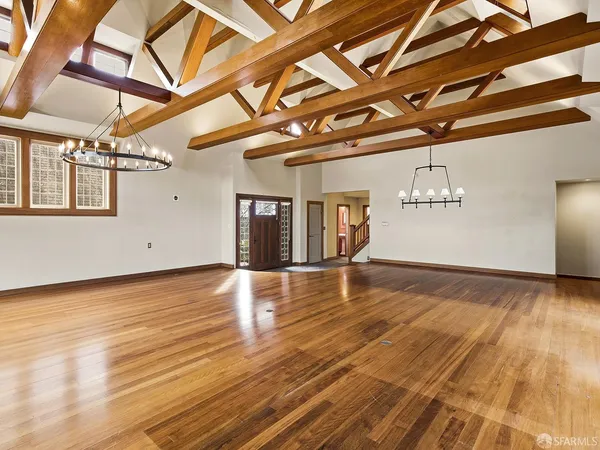 a large kitchen with granite countertop a stove a sink dishwasher a refrigerator and cabinets with wooden floor