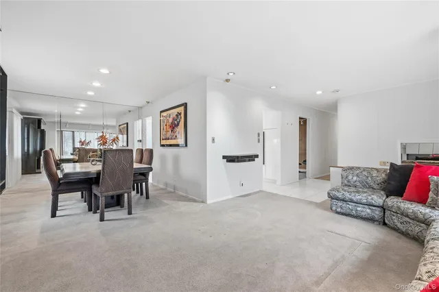 a living room with furniture and a dining table with kitchen view