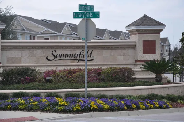a view of sign board with flower plants