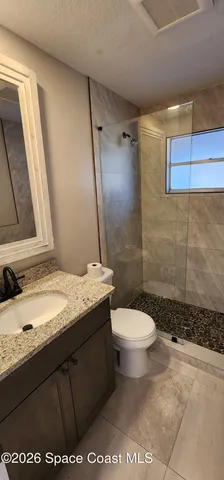 a bathroom with a granite countertop sink toilet and shower