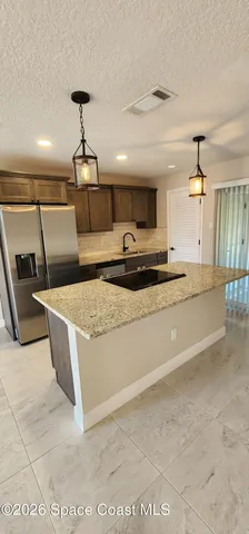a kitchen with stainless steel appliances granite countertop a sink and a stove